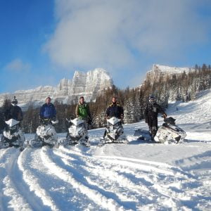 Snowmobilers line up in the scenery during a ride.