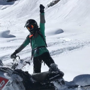 Woman celebrates on snowmobile