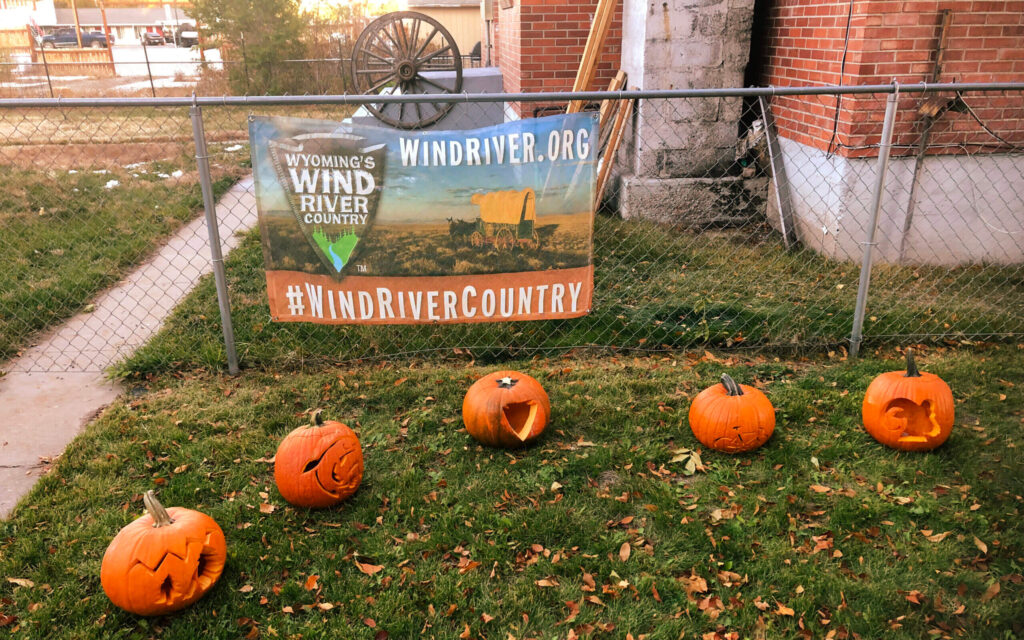 Carved pumpkins line the lawn in front of a Wind River Country banner at the annual Pumpkin Trail event in Riverton Museum.