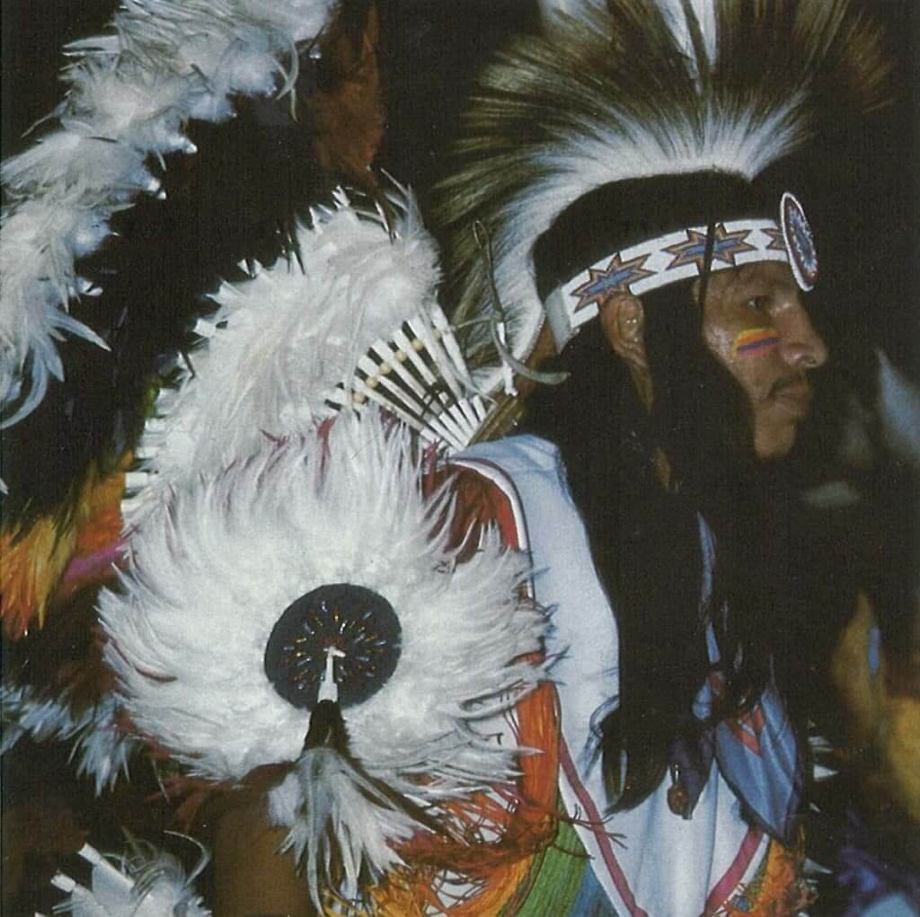 A fancy dancer wearing traditional Native American regalia with a large feathered headdress in Wind River Country.