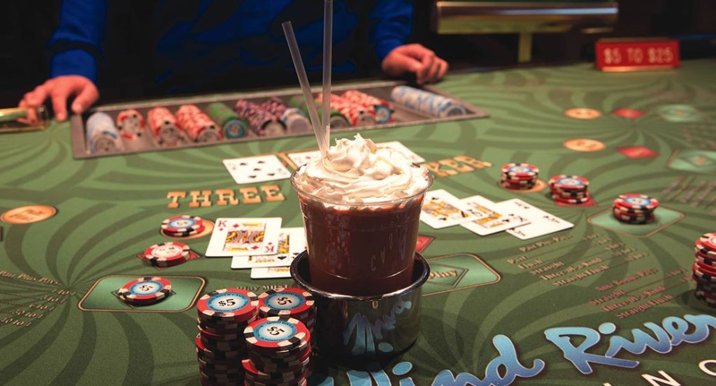 lose-up of a lively gaming table at Wind River Casino, complete with poker chips, cards, and a signature drink, making it a must-visit destination near Riverton.