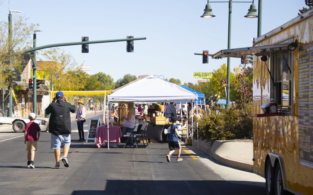 Families exploring Main Street in Riverton, WY, during a lively festival with food trucks, vendors, and entertainment.