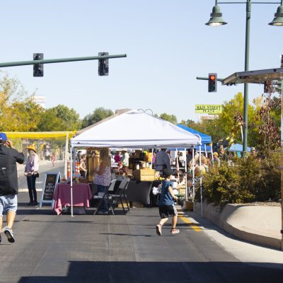 Families exploring Main Street in Riverton, WY, during a lively festival with food trucks, vendors, and entertainment.