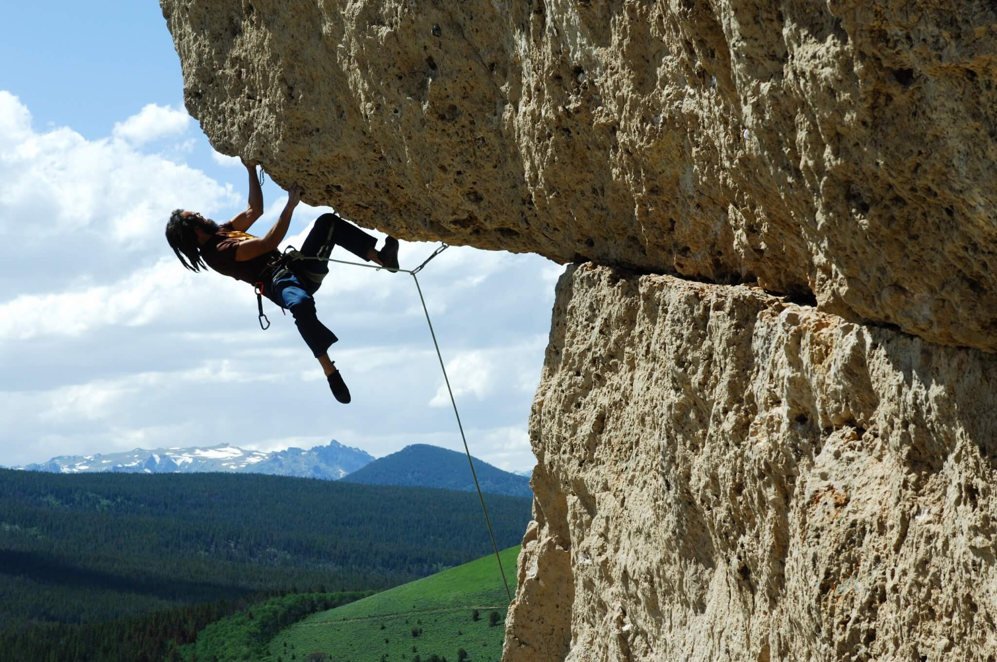 Rock climber ascending a challenging climbing move