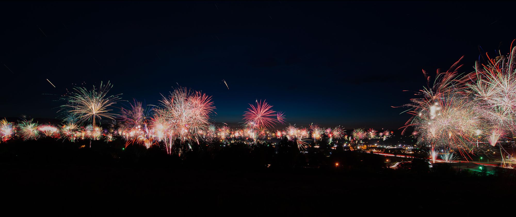 Fireworks at night over city streets.